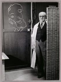 Henri Matisse standing against a screen and drawing with chalk - Брассай